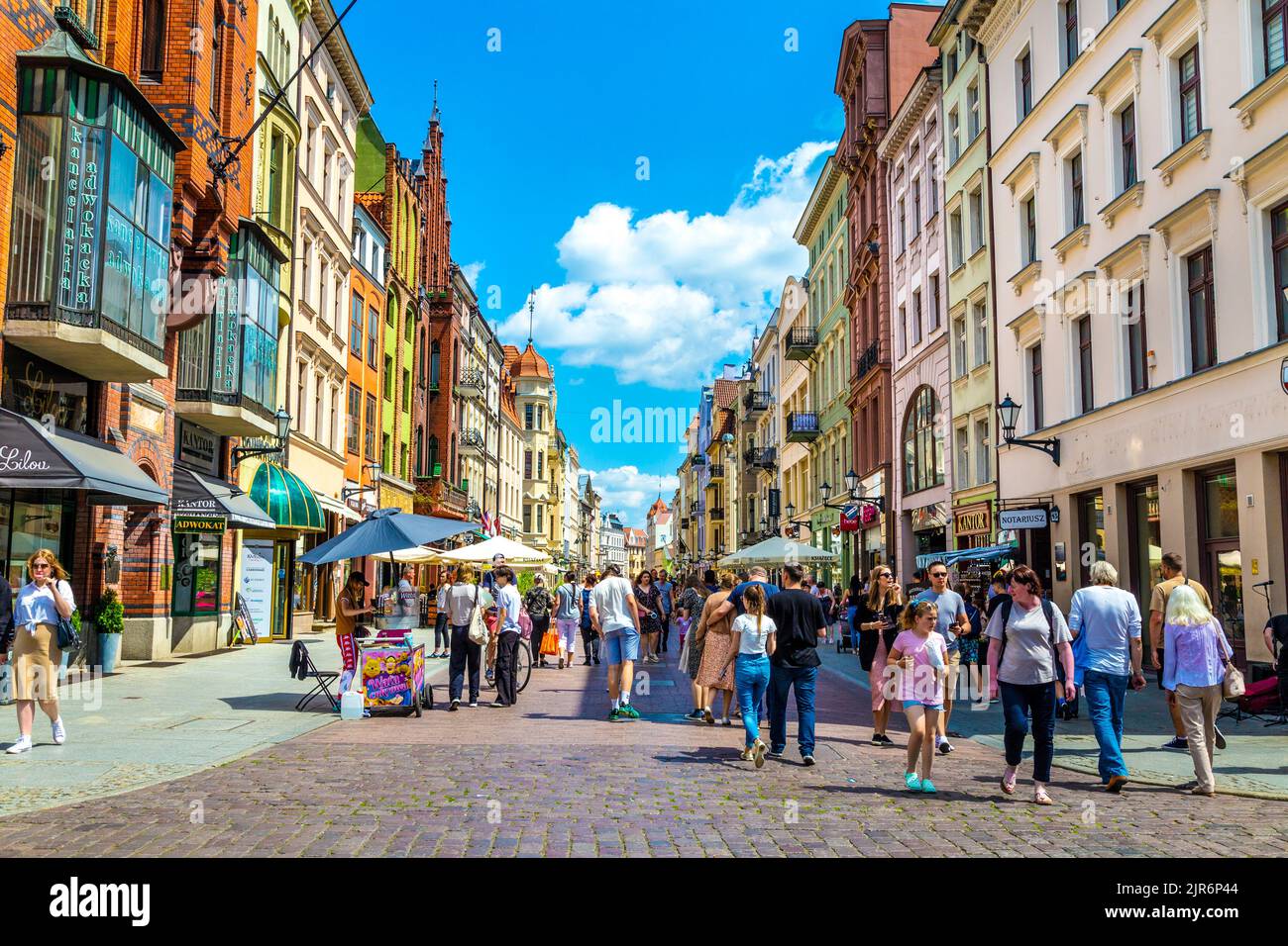 Rue Szeroka animée par des gens et des maisons colorées dans la vieille ville de Torun, en Pologne Banque D'Images