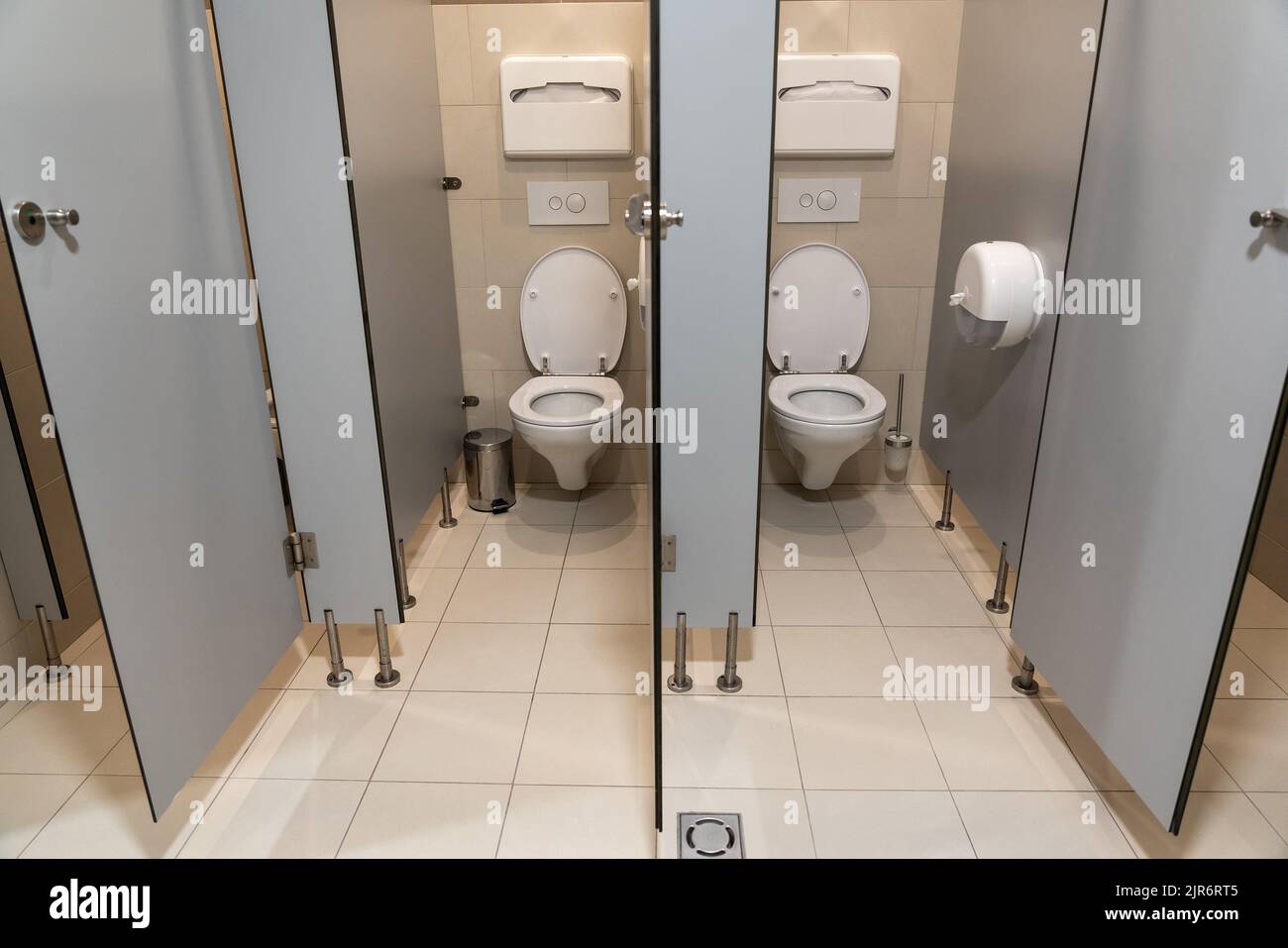 Rangée de cabines de toilette vides avec porte ouverte dans une salle de toilettes publique Banque D'Images