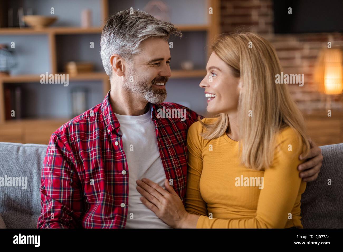 Joyeux mari caucasien d'âge moyen avec la barbe et la femme regardent les uns les autres, parler, profiter de temps libre Banque D'Images
