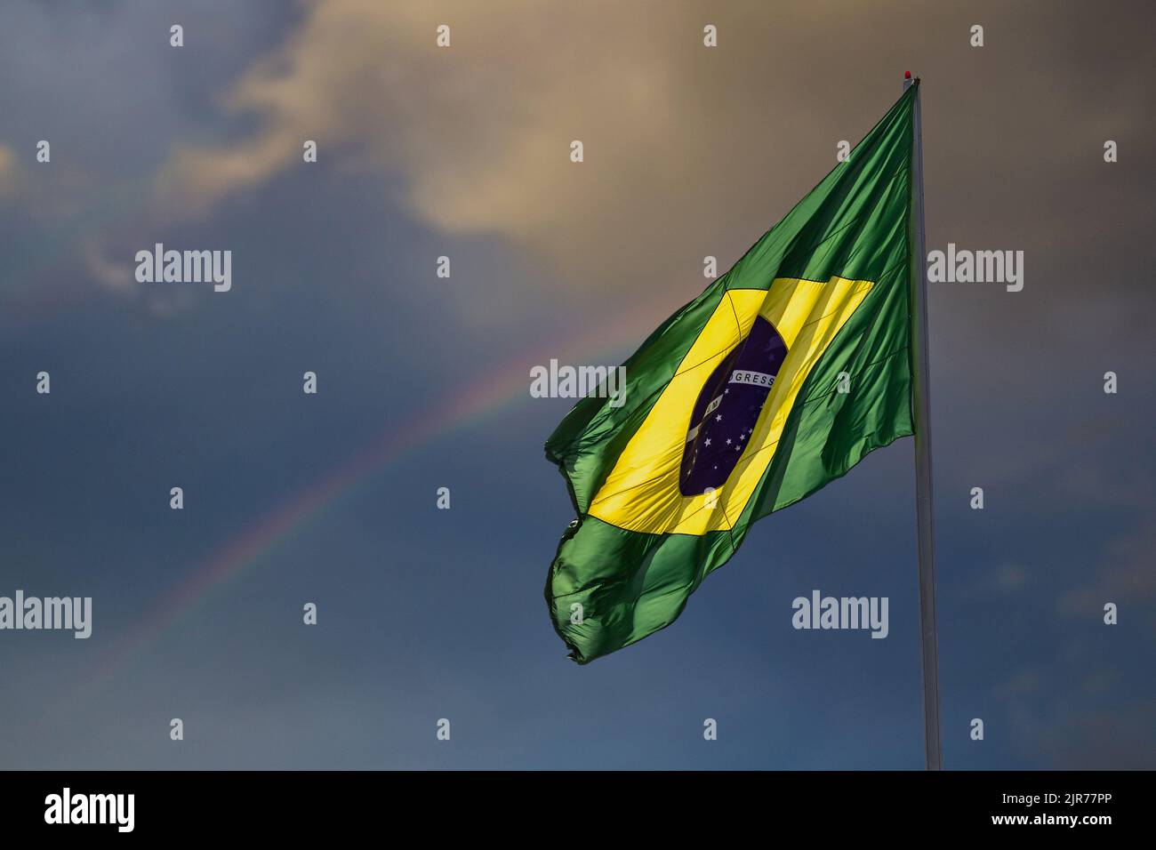 Goias, Brésil – 22 août 2022 : drapeau brésilien volant, volant dans le vent et avec le ciel et l'arc-en-ciel en arrière-plan. Banque D'Images