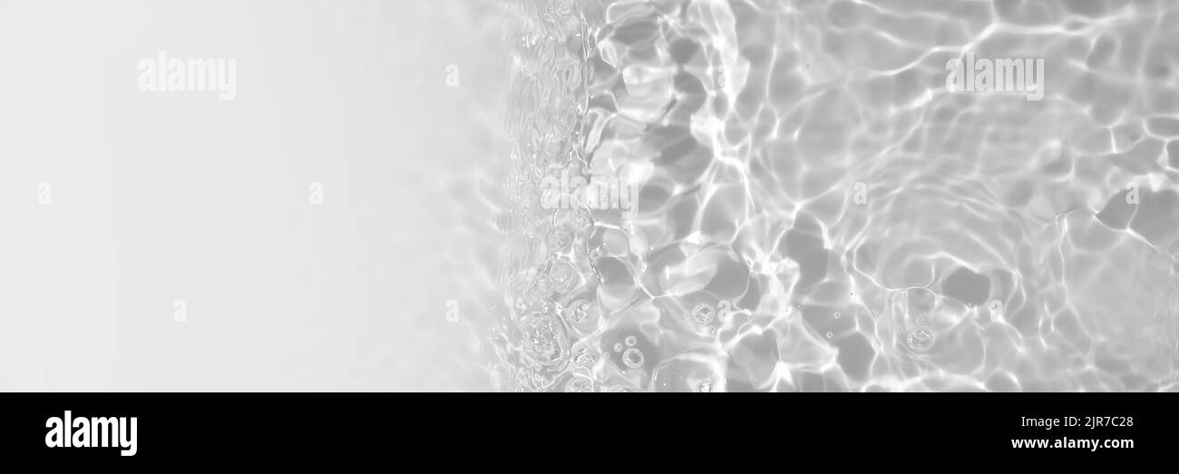 Texture transparente et claire de la surface de l'eau calme avec vagues, éclaboussures et bulles. Arrière-plan tendance de la nature abstraite. Vagues d'eau blanche et grise en plein soleil Banque D'Images