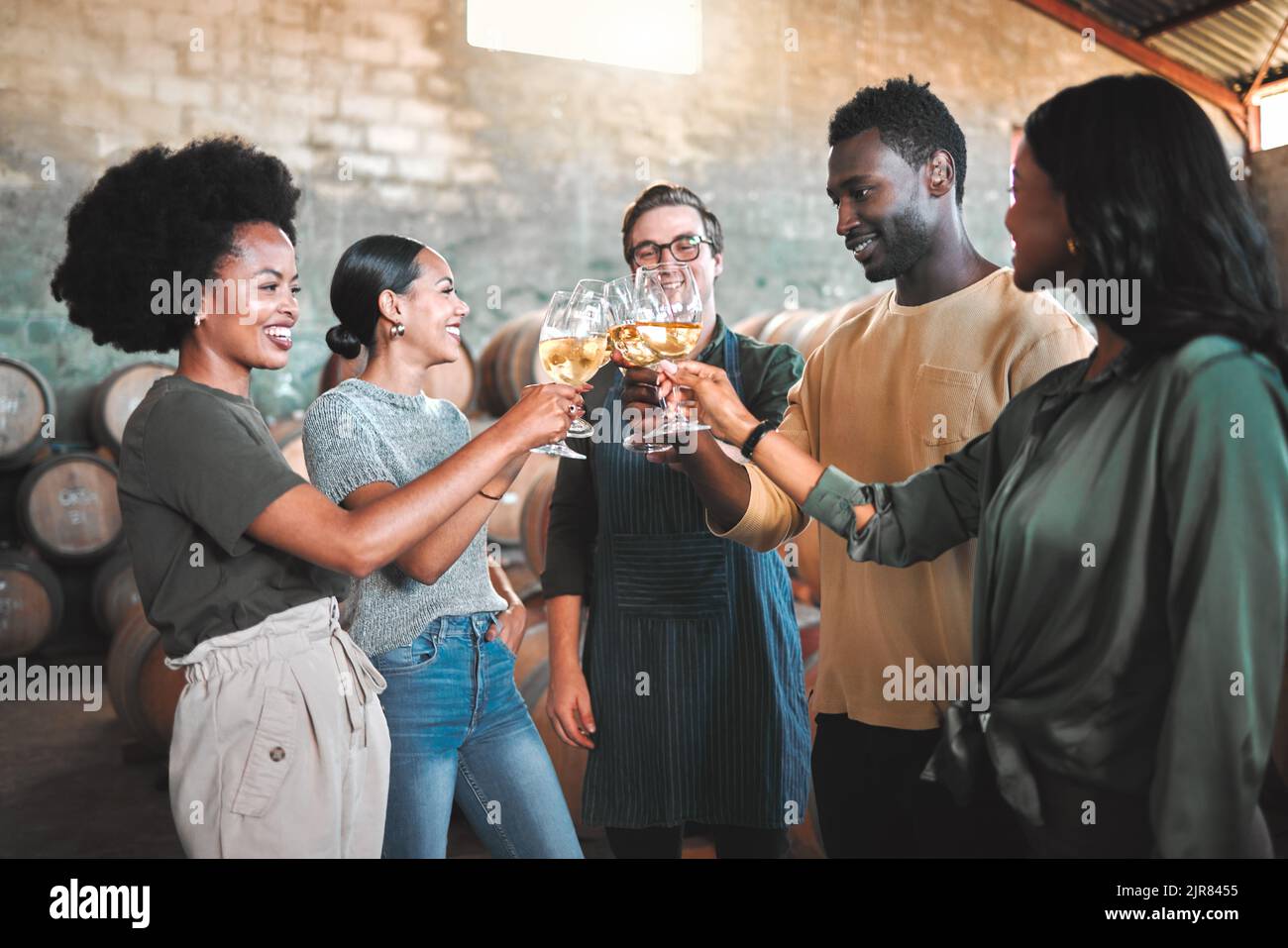 Dégustation de vins entre amis, en dégustant des cheers et des toasts, célébrez avec des verres de champagne dans la cave, la distillerie et la brasserie. Groupe de heureux, diversité et sourire Banque D'Images