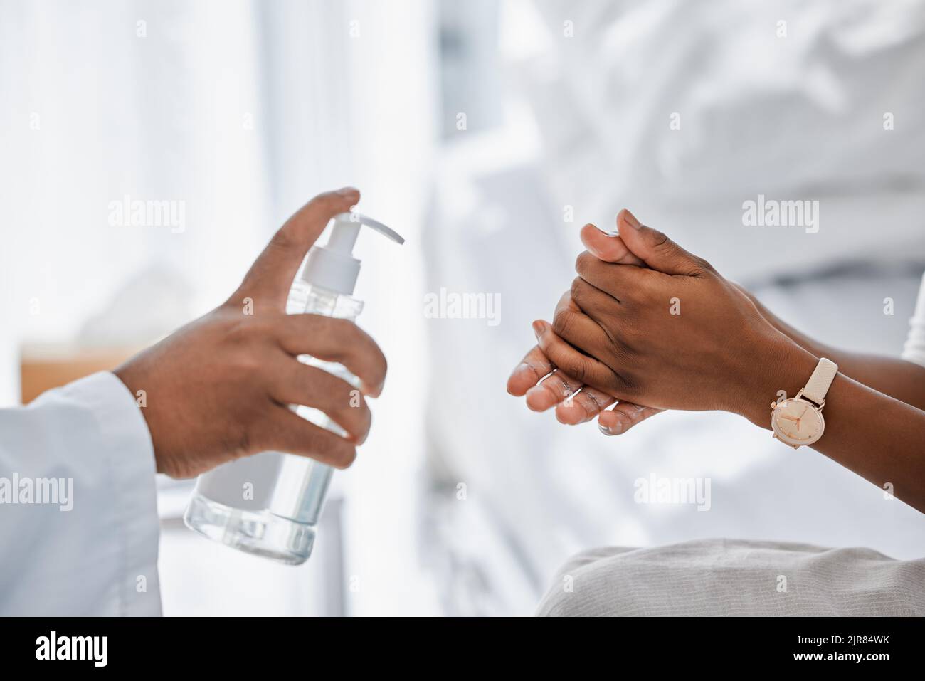 Médecin donnant au patient un désinfectant pour les mains pour la protection contre les covidés, l'hygiène et le protocole dans l'hôpital ou la clinique. La sécurité des soins de santé, les germes de la grippe et le nettoyage des mains Banque D'Images
