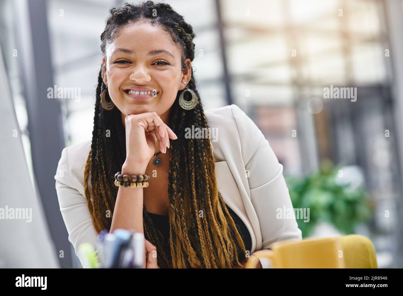 Le succès met toujours un sourire sur mon visage. Portrait court d'une jeune femme d'affaires attirante assise à son bureau. Banque D'Images