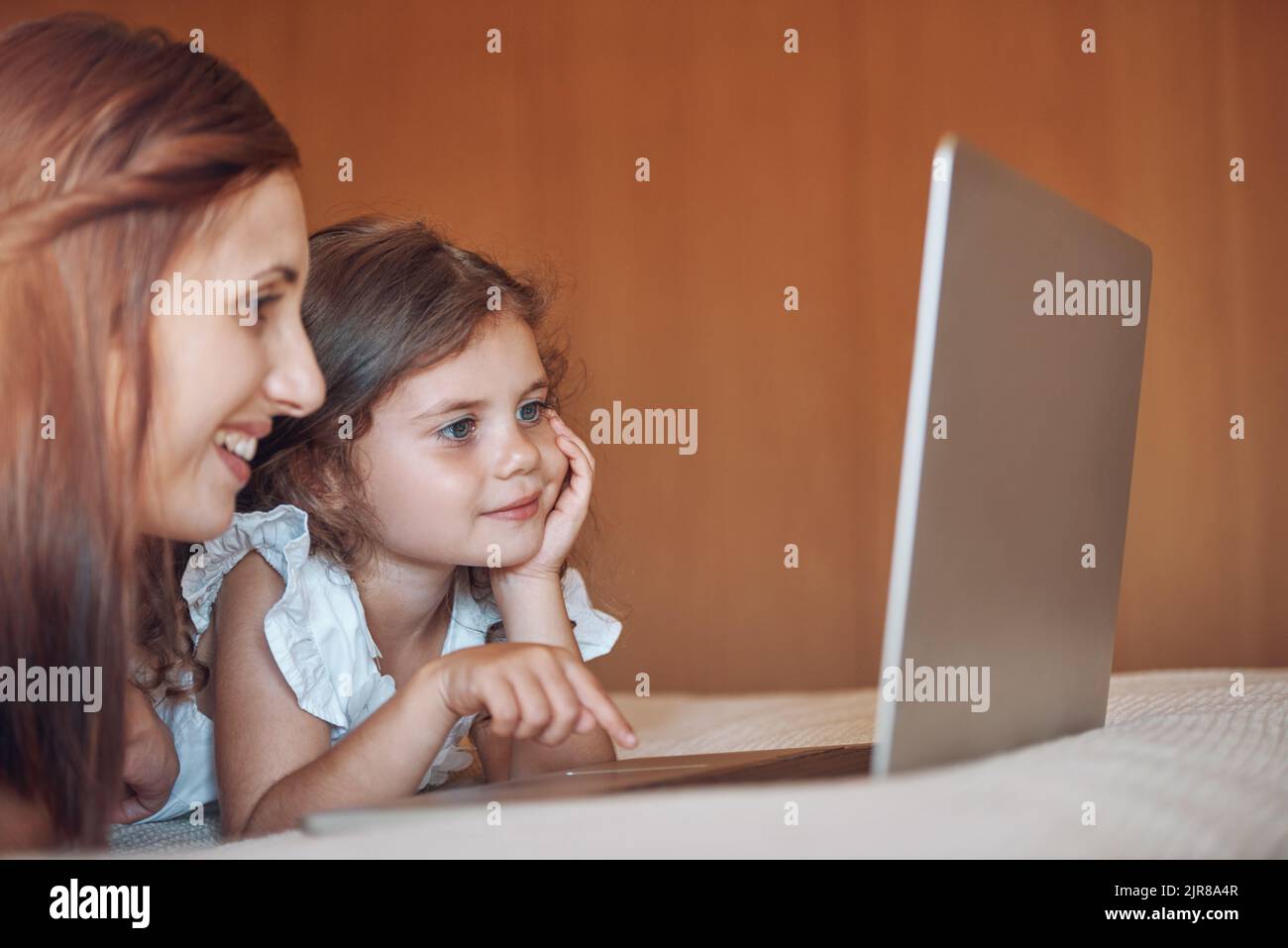 Utilisation d'Internet en toute sécurité sous la supervision de Mme une mère et sa petite fille utilisant un ordinateur portable ensemble à la maison. Banque D'Images