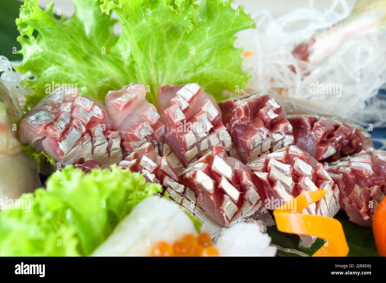 AJI Sashimi, maquereau coupé en tranches frais servi sur une assiette de sashimi mori décorée de laitue verte et de radis déchiquetés. Buffet de cuisine japonaise. Banque D'Images