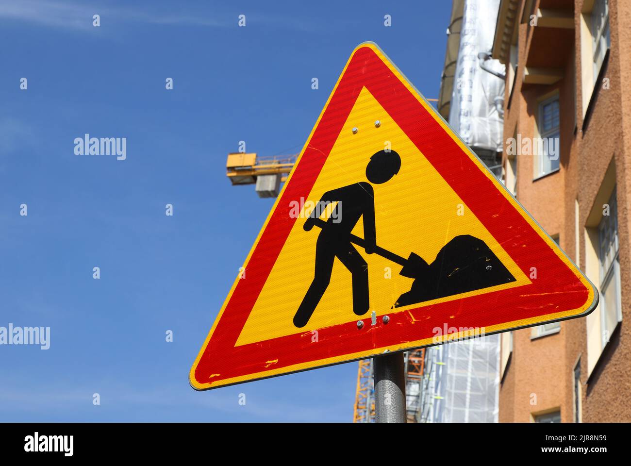 Panneau d'avertissement de travaux routiers sans joint devant un chantier de construction. Banque D'Images