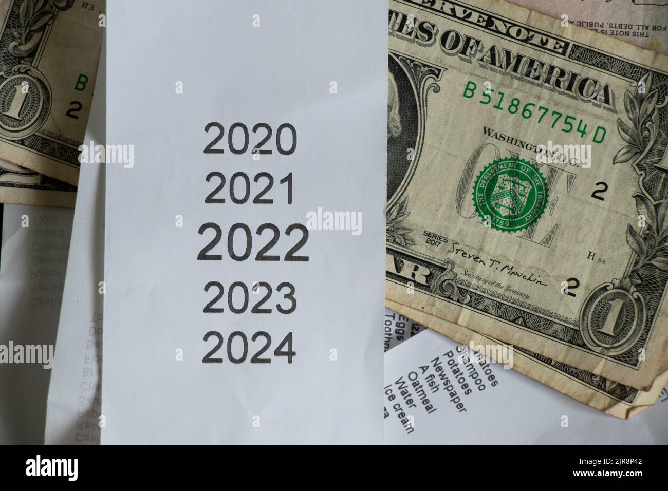 Liste des années 2020 2021 2022 2023 sur la caisse qui se trouve près des dollars américains, le reçu des ventes et l'argent, le sujet financier, les revenus en 2022 Banque D'Images