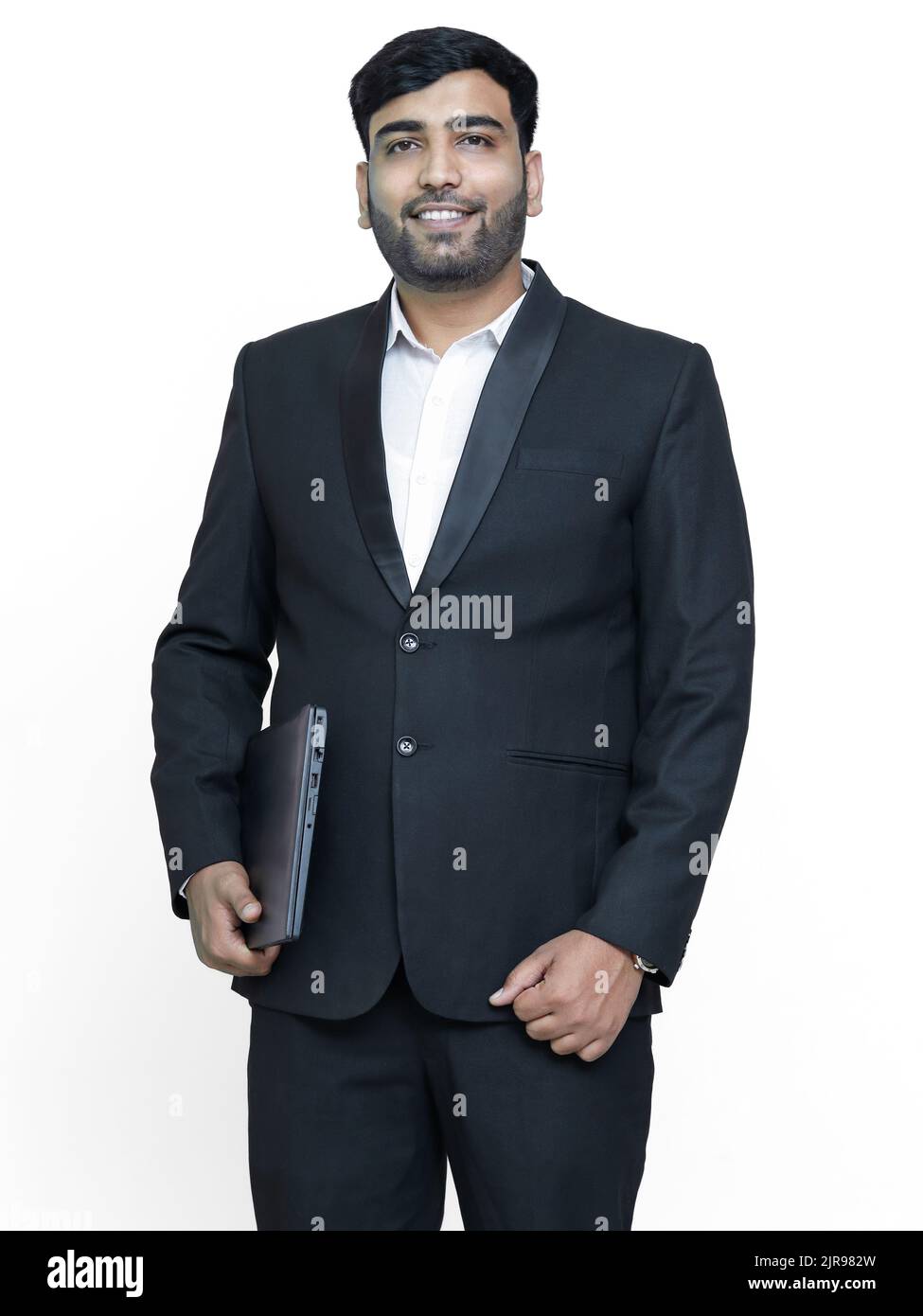 Modèle mâle regardant la caméra avec ordinateur portable à la main. Banque D'Images