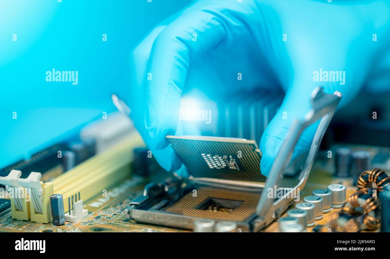 Ingénieur en électronique mettant la puce d'ordinateur sur la prise. Chipset sur la carte électronique de la carte mère du PC. Puce UC. Composants électroniques. Banque D'Images