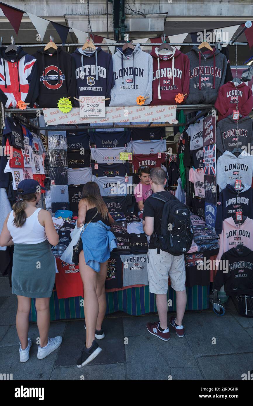Les touristes achetant des T-shirts au marché Covent Garden à Londres en été Banque D'Images