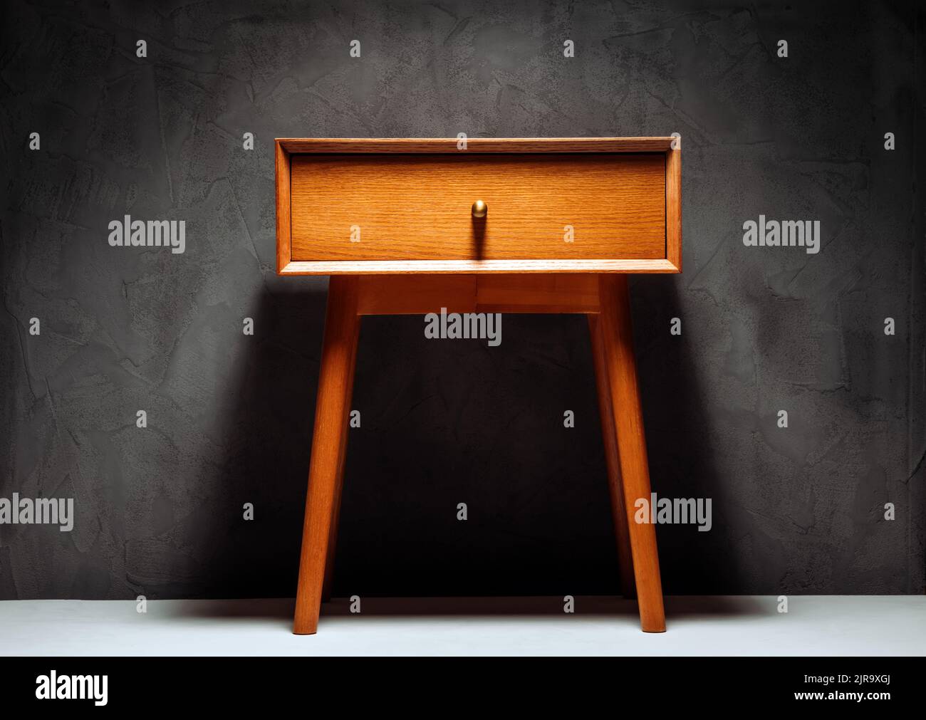 Table de nuit ou table de chevet près d'un mur en béton Banque D'Images