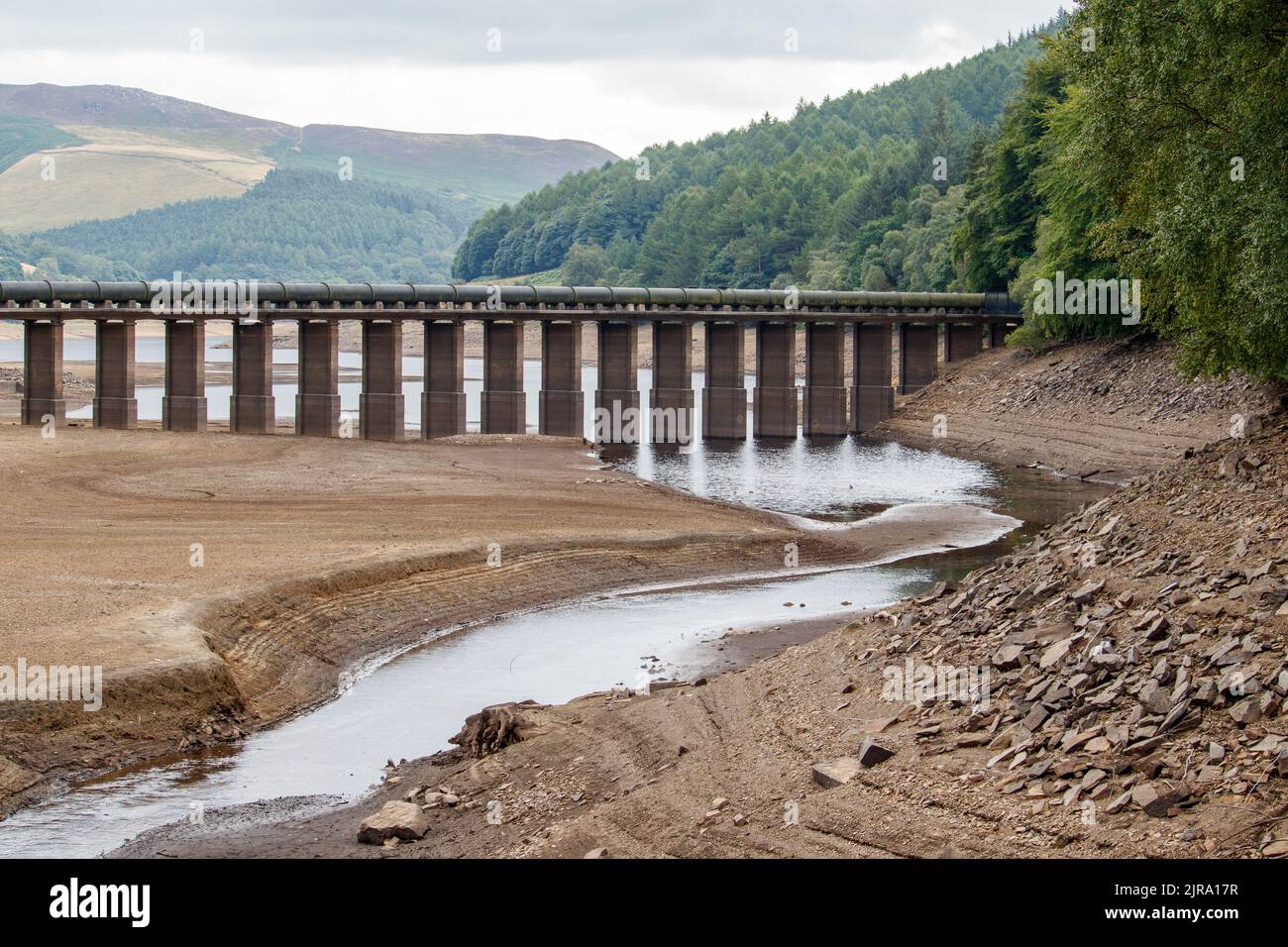 Le niveau d'eau est réduit à un petit ruisseau à l'extrémité supérieure du réservoir Ladybower, près du centre d'accueil. Le réservoir Ladybower pendant le temps sec et la sécheresse de l'été 2022. Ladybower Reservoir est un grand réservoir artificiel en forme de y, le plus bas de trois dans la vallée supérieure du Derwent, dans le Derbyshire, en Angleterre. Banque D'Images