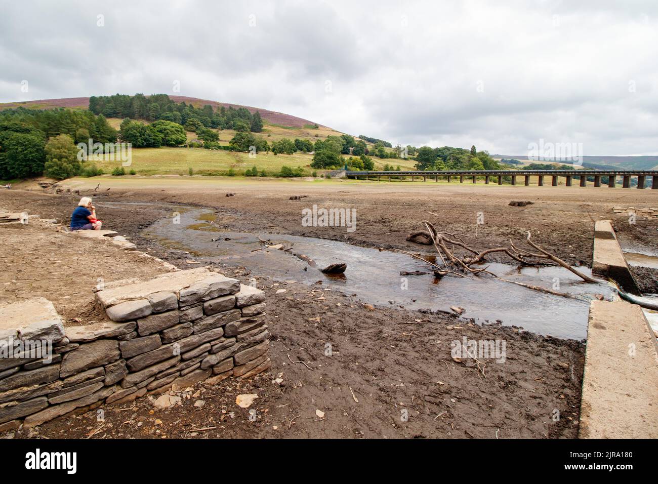 Le niveau d'eau est réduit à un petit ruisseau à l'extrémité supérieure du réservoir Ladybower près du cenre visiteur. Le réservoir Ladybower pendant le temps sec et la sécheresse de l'été 2022. Ladybower Reservoir est un grand réservoir artificiel en forme de y, le plus bas de trois dans la vallée supérieure du Derwent, dans le Derbyshire, en Angleterre. Banque D'Images