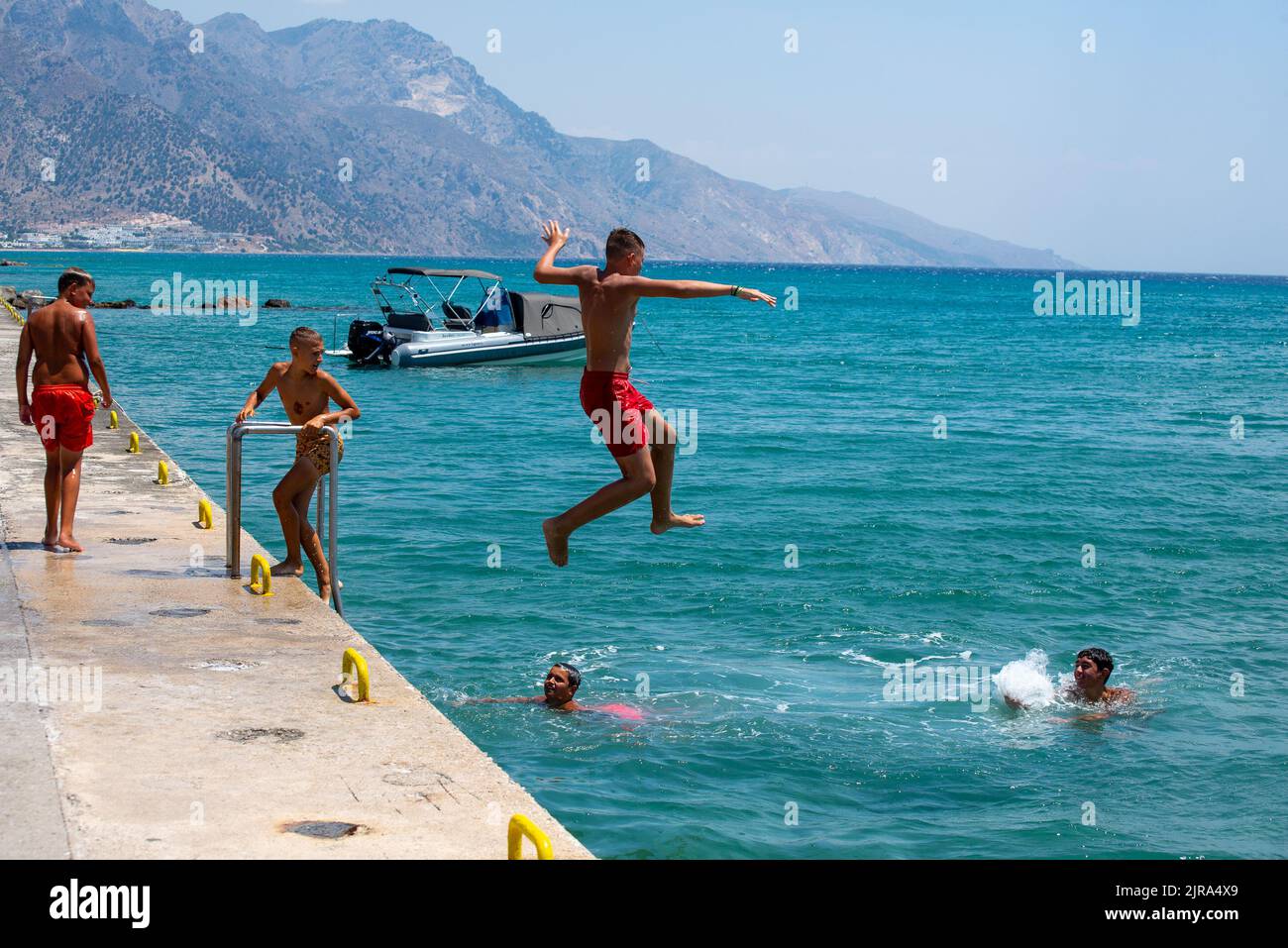 Jeunes garçons sautant et nageant dans la mer à Kardamaina, Kos, Grèce Banque D'Images