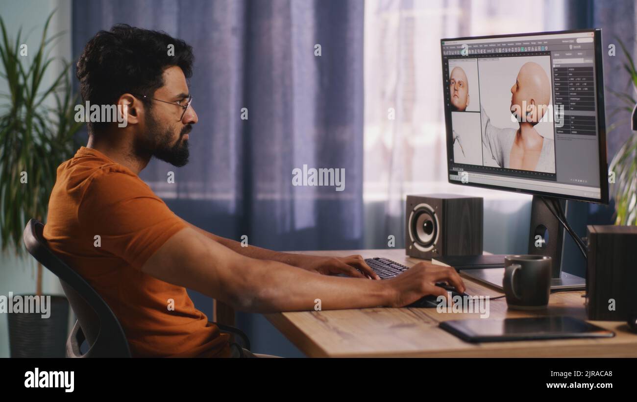 Vue arrière de l'homme anonyme créant 3D modèle de personnage de jeu vidéo tout en étant assis à table et en travaillant sur le projet à distance à la maison Banque D'Images