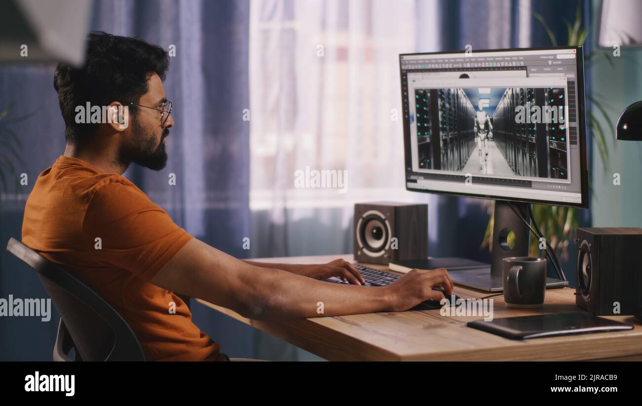 Développeur indien utilisant un ordinateur pour créer et rendre 3D modèle de robot futuriste sur ordinateur pendant le travail dans un salon sombre en soirée Banque D'Images