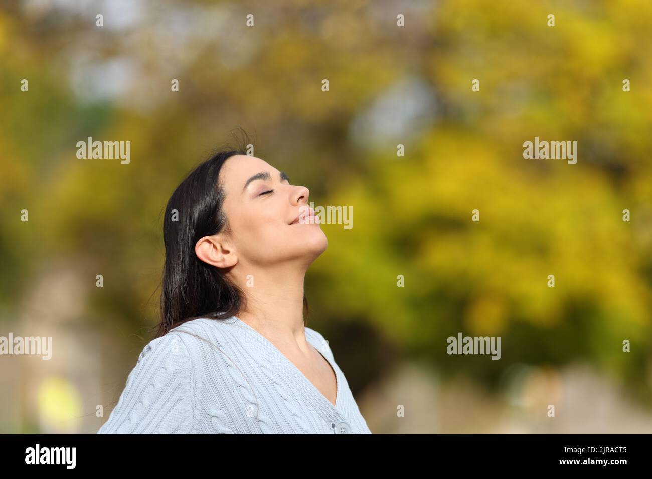 Une femme heureuse se détend en respirant l'air frais d'un parc Banque D'Images