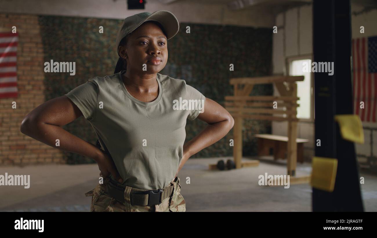 Une femme militaire afro-américaine respire et chauffe les bras pendant son entraînement dans la salle de gym de la base militaire américaine Banque D'Images