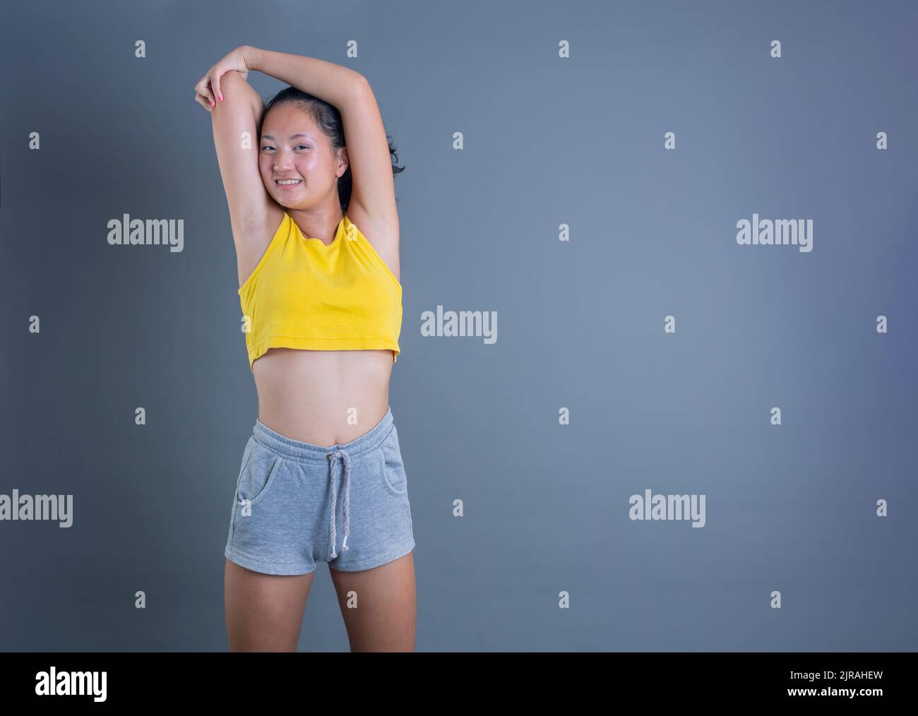 jolie jeune fille de vêtements de sport d'origine asiatique isolée sur fond gris Banque D'Images