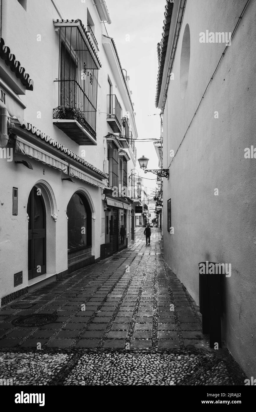 Un cliché vertical noir et blanc d'une rue vide solitaire avec des bâtiments résidentiels à Malaga, Espagne Banque D'Images