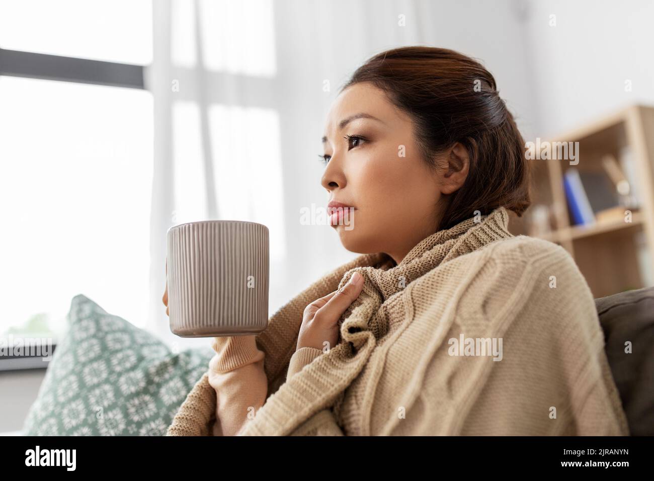 femme asiatique malade qui boit du thé chaud à la maison Banque D'Images