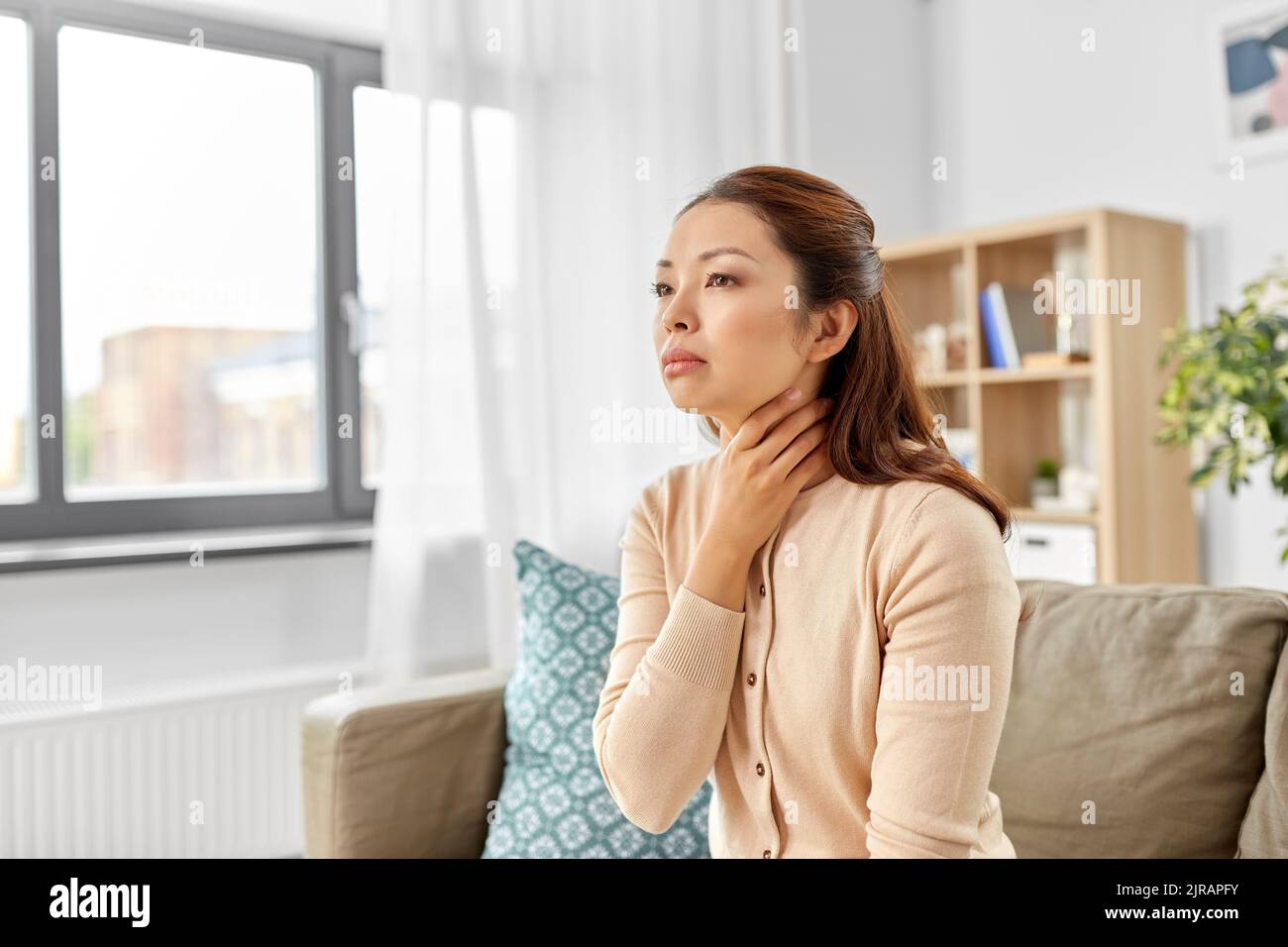 malade asiatique femme touchant son mal de gorge à la maison Banque D'Images