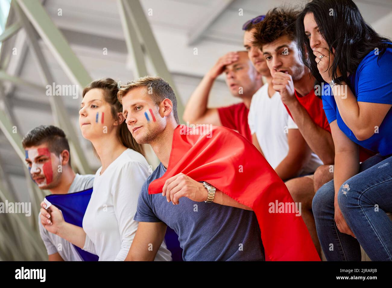 Curieux fans avec drapeau français regarder des événements sportifs au stade Banque D'Images