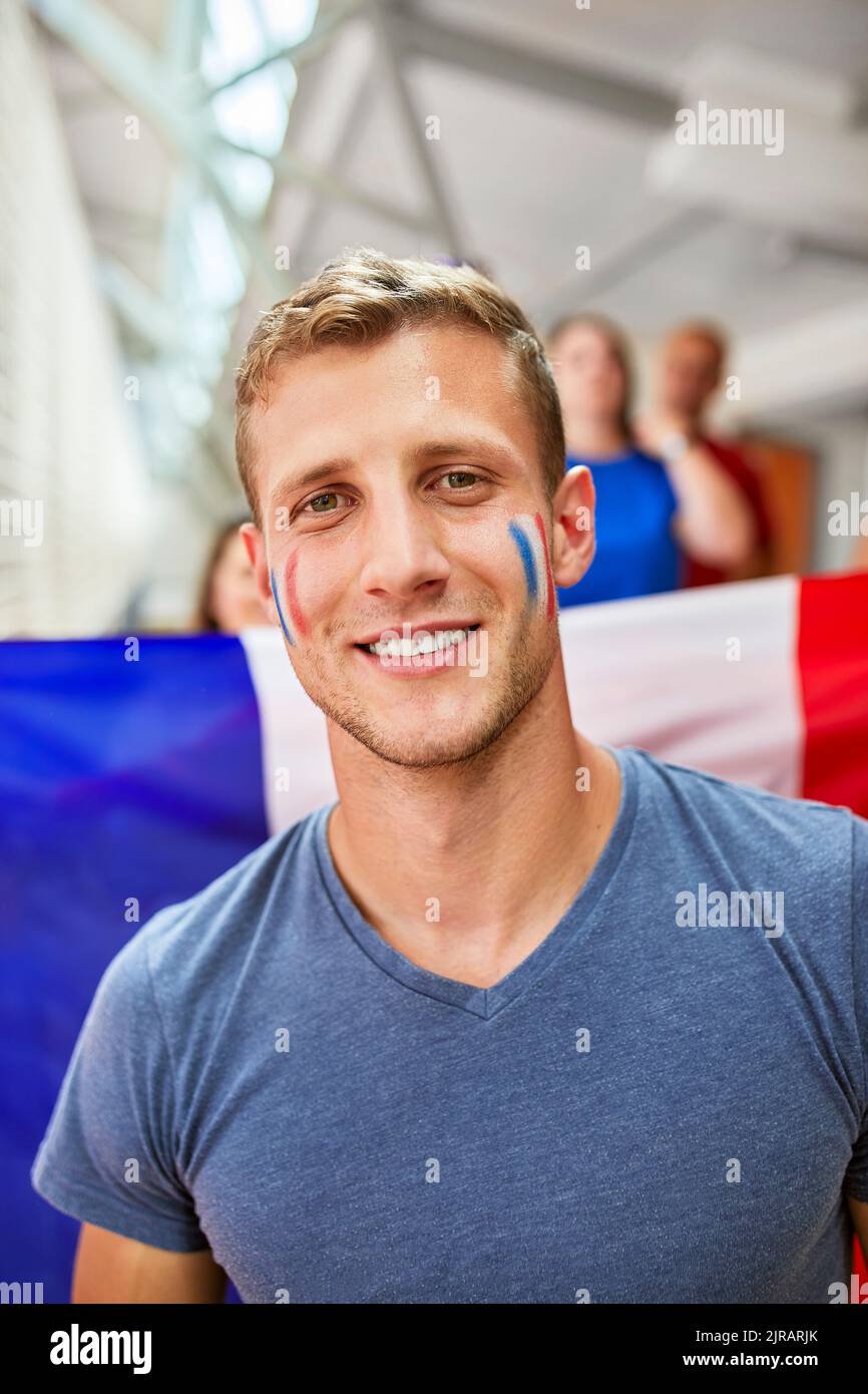 Homme souriant avec drapeau français peint sur le visage Banque D'Images