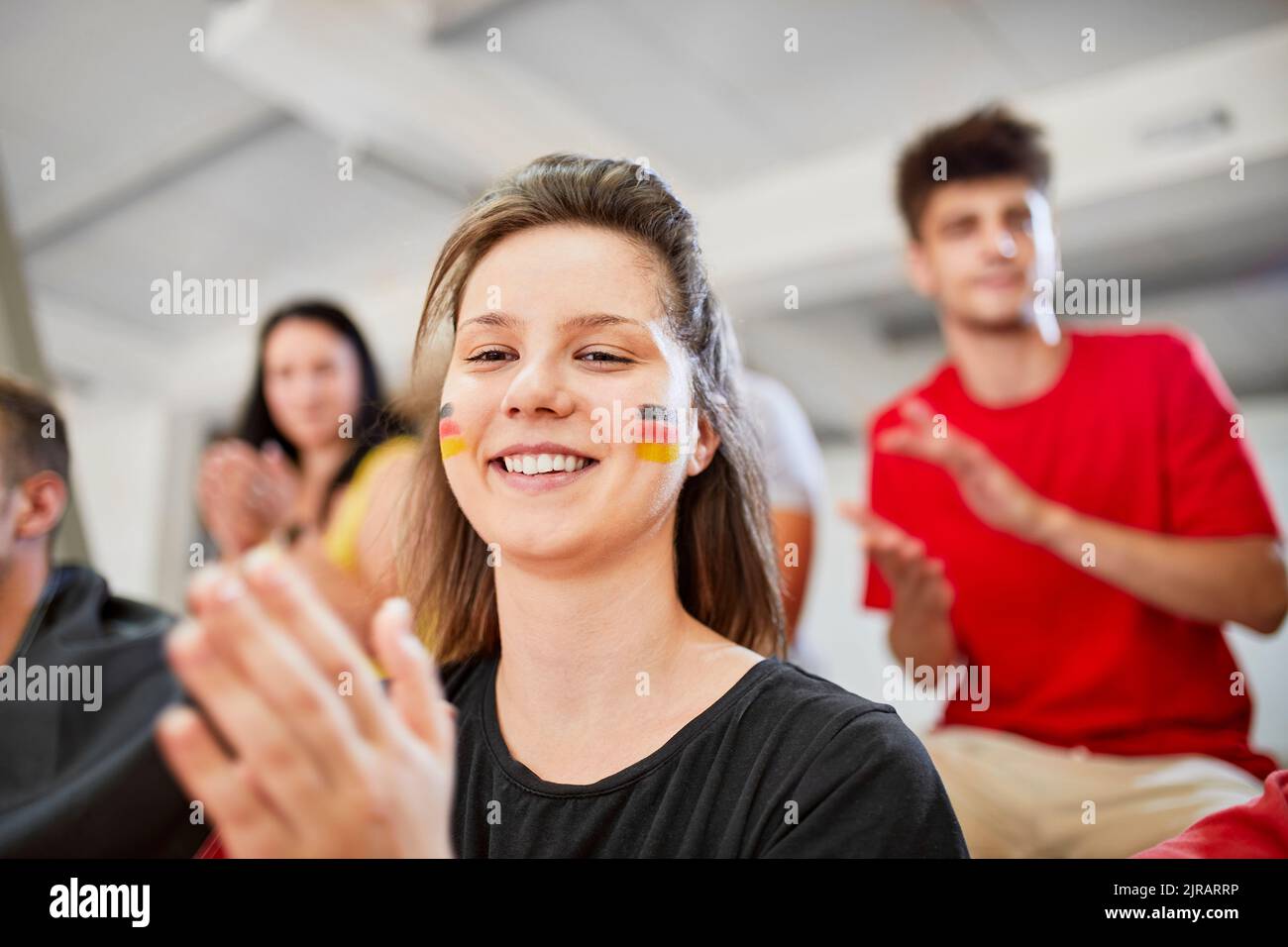 Femme souriante applaudissant à un événement sportif dans le stade Banque D'Images