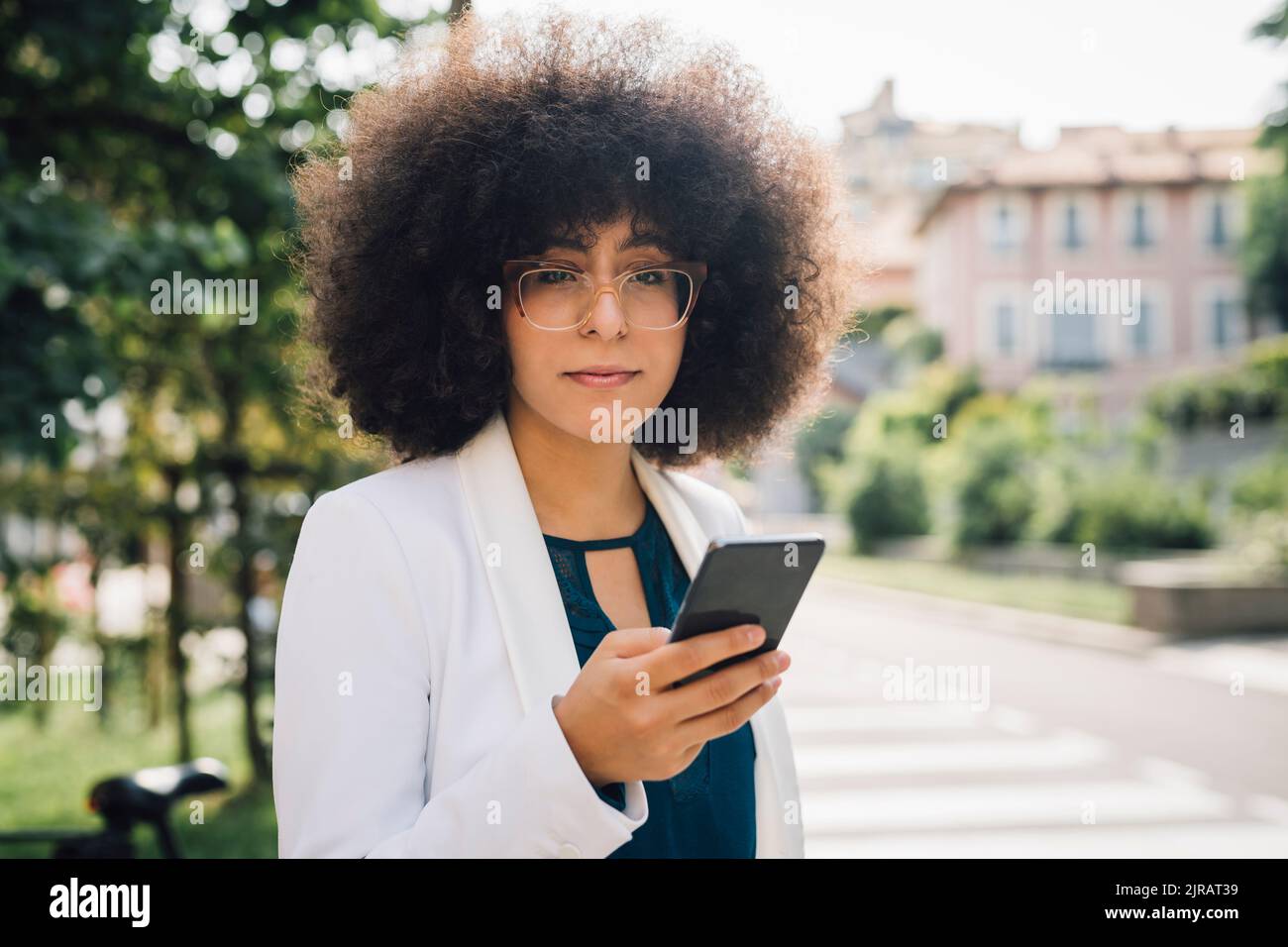 Femme d'affaires attentionnés avec un téléphone intelligent par beau temps Banque D'Images