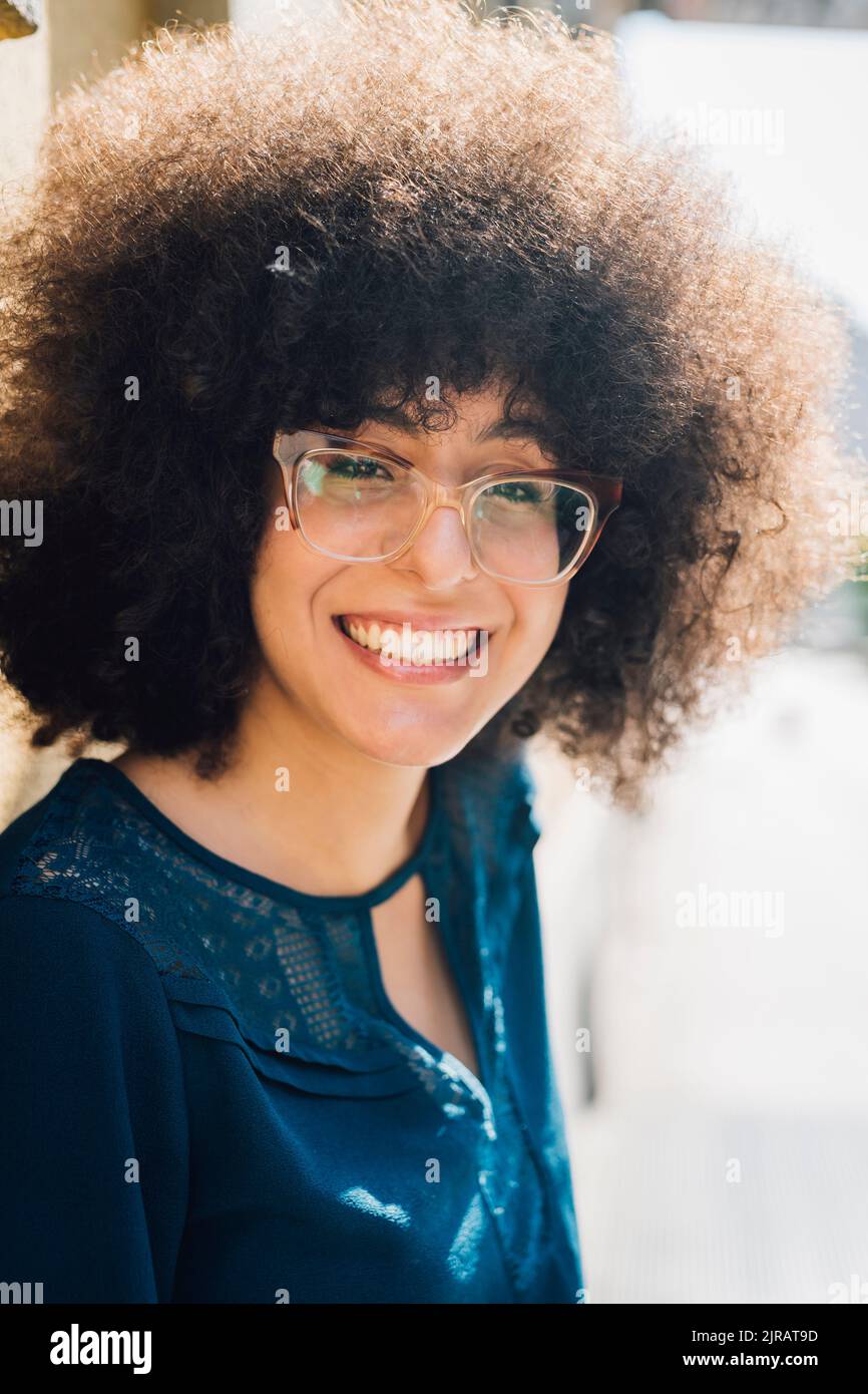 Femme d'affaires souriante avec une coiffure afro Banque D'Images