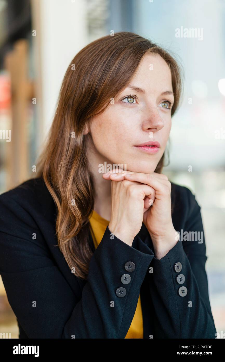 Femme d'affaires attentionnés avec les mains sur le menton Banque D'Images