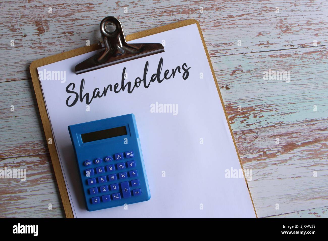 Vue de dessus du presse-papiers avec texte actionnaires et calculatrice. Concept d'entreprise Banque D'Images