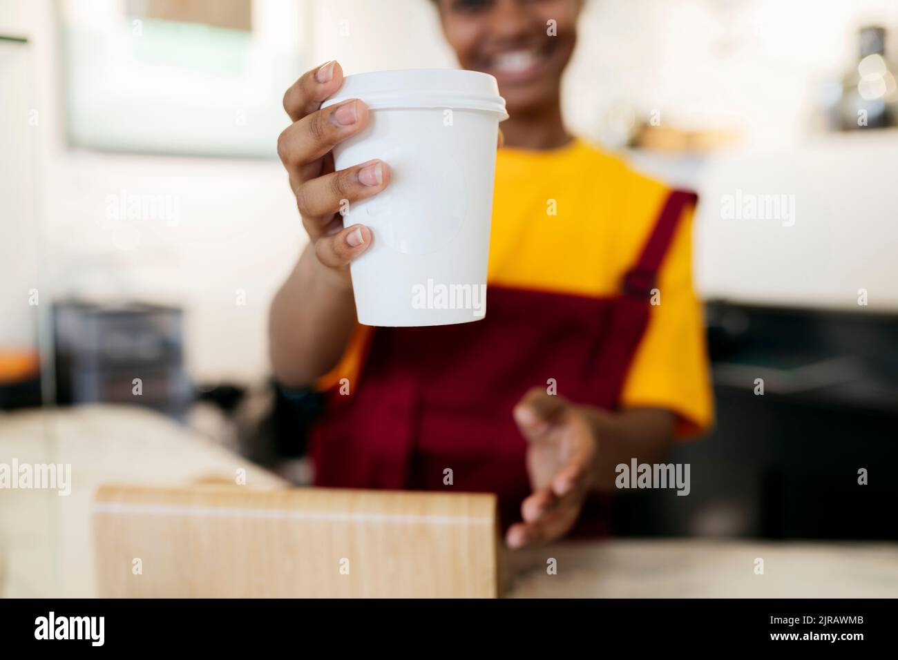 Femme offrant une tasse de café jetable Banque D'Images
