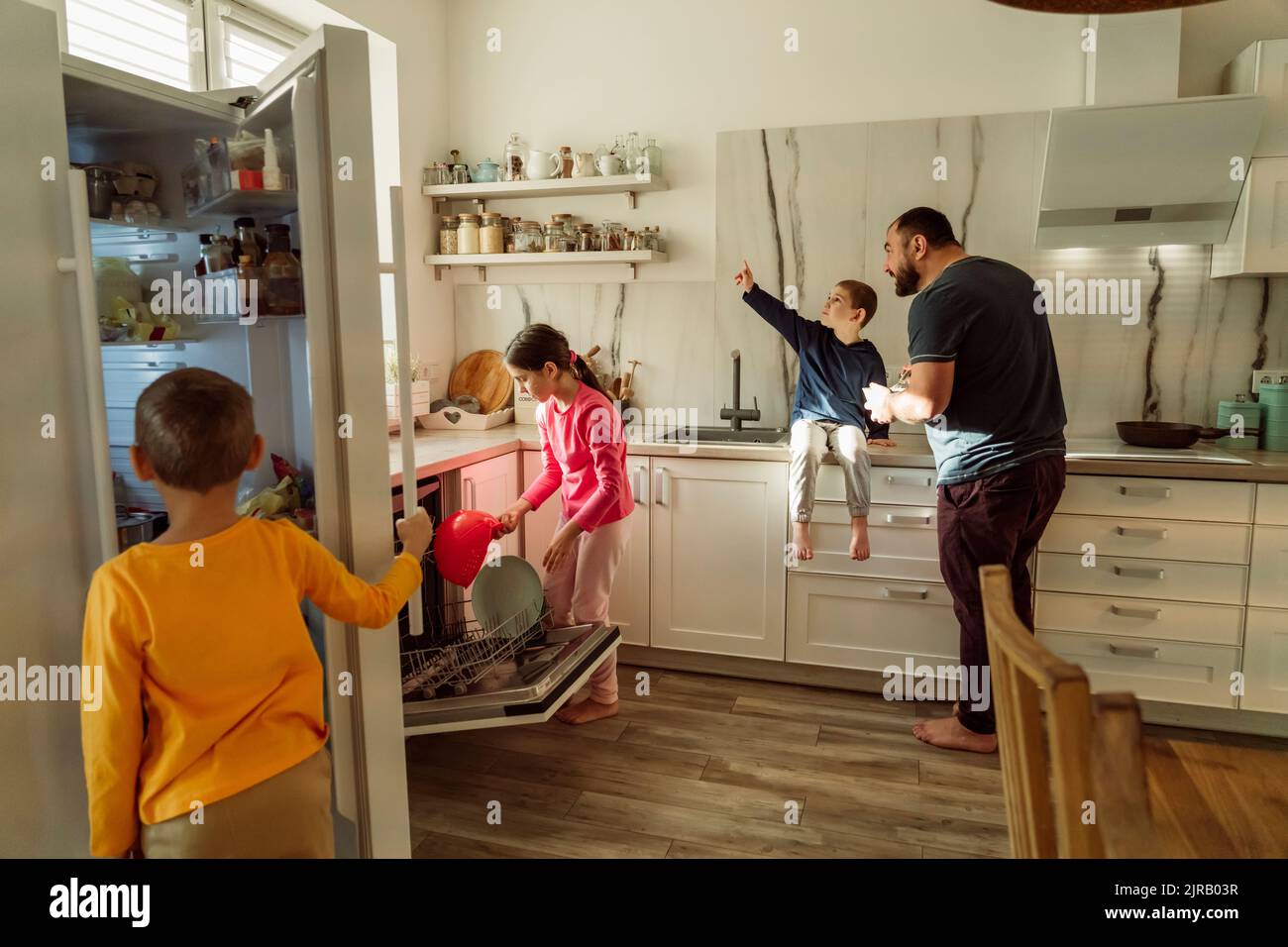 Enfants avec père dans la cuisine à la maison Banque D'Images