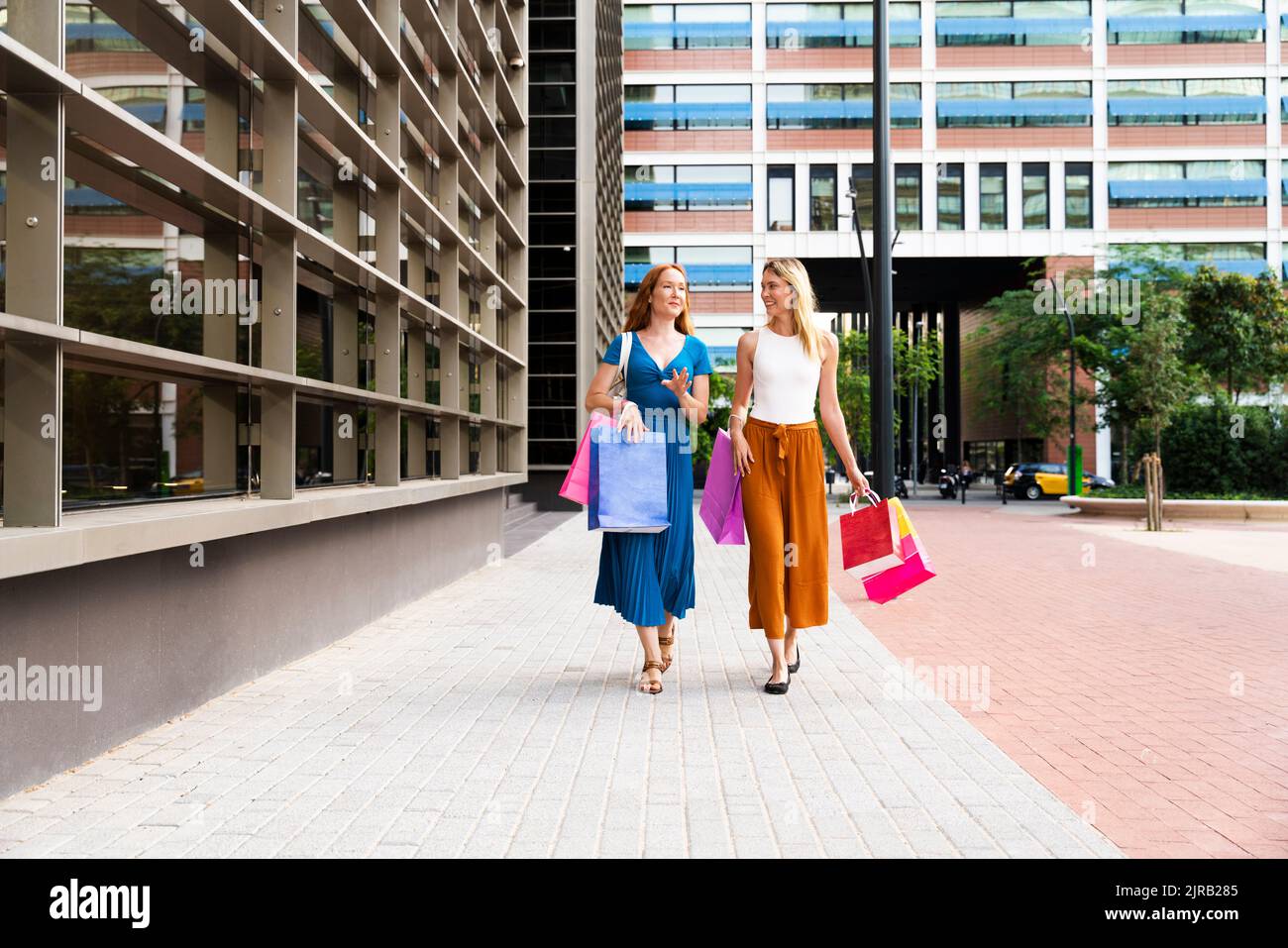 Amis avec des sacs de shopping marchant ensemble sur la piste de marche Banque D'Images Amis avec des sacs de shopping marchant ensemble sur la piste de marche Banque D'Images