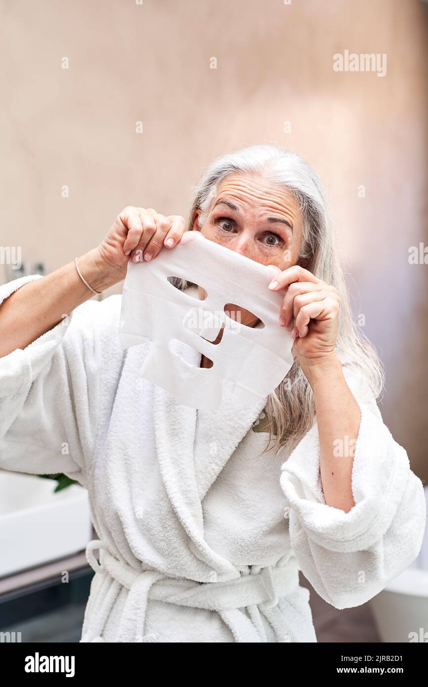 Femme joueur avec masque facial dans la salle de bains Banque D'Images
