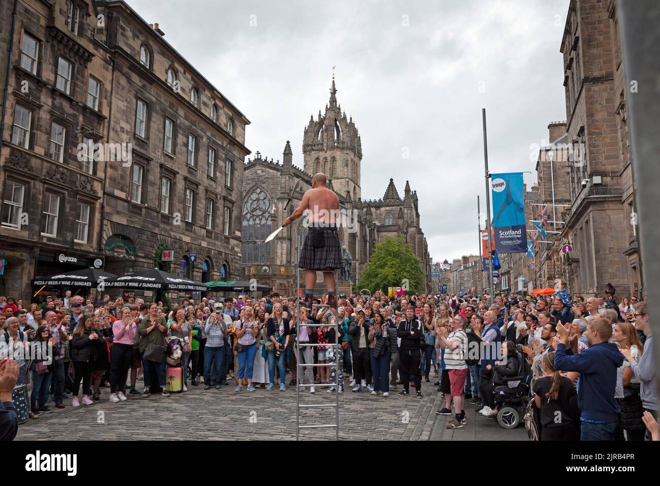 Royal Mile et Grassmarket, Édimbourg, Écosse, Royaume-Uni. 23rd août 2022. La troisième semaine du Festival Fringe d'Édimbourg a moins de gens dehors et environ bien que tout à fait occupé dans les spectacles de rue et les restaurants. Photo : Pete Anderson s'emmêle d'un public à la jonglerie au sabre. Credit: Archwhite/alamy Live news. Banque D'Images