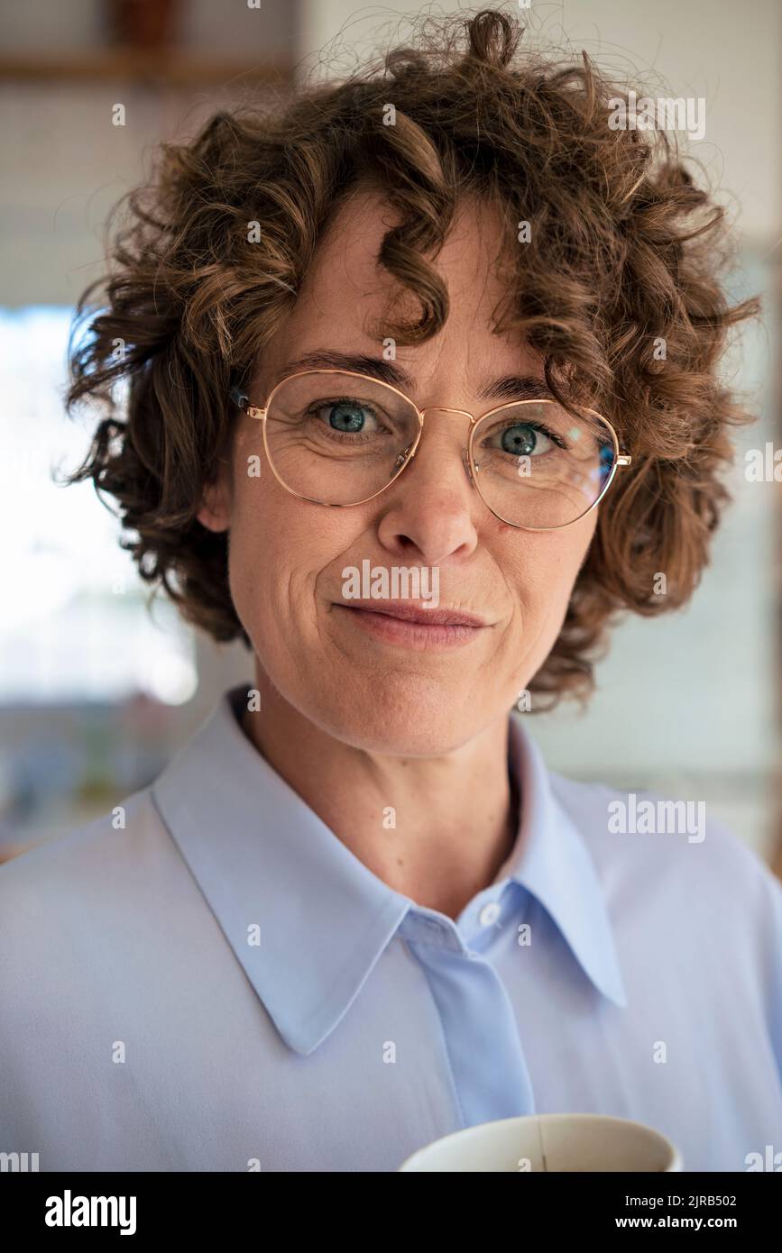 Femme d'affaires souriante avec cheveux bruns portant des lunettes Banque D'Images