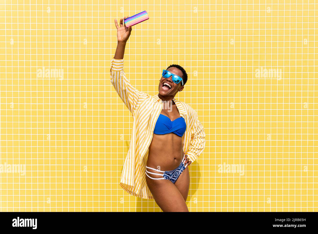 Femme gaie en bikini emportant le selfie via un smartphone Banque D'Images