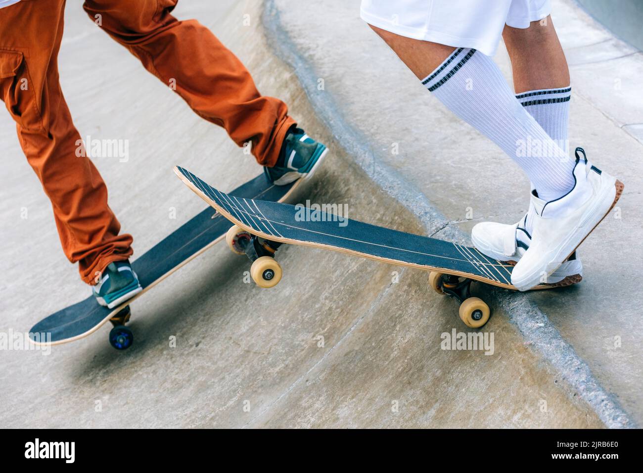Amis avec des planches à roulettes dans le parc de skate Banque D'Images