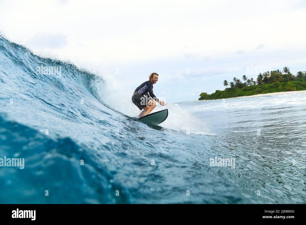 Surfer sur vague en mer Banque D'Images