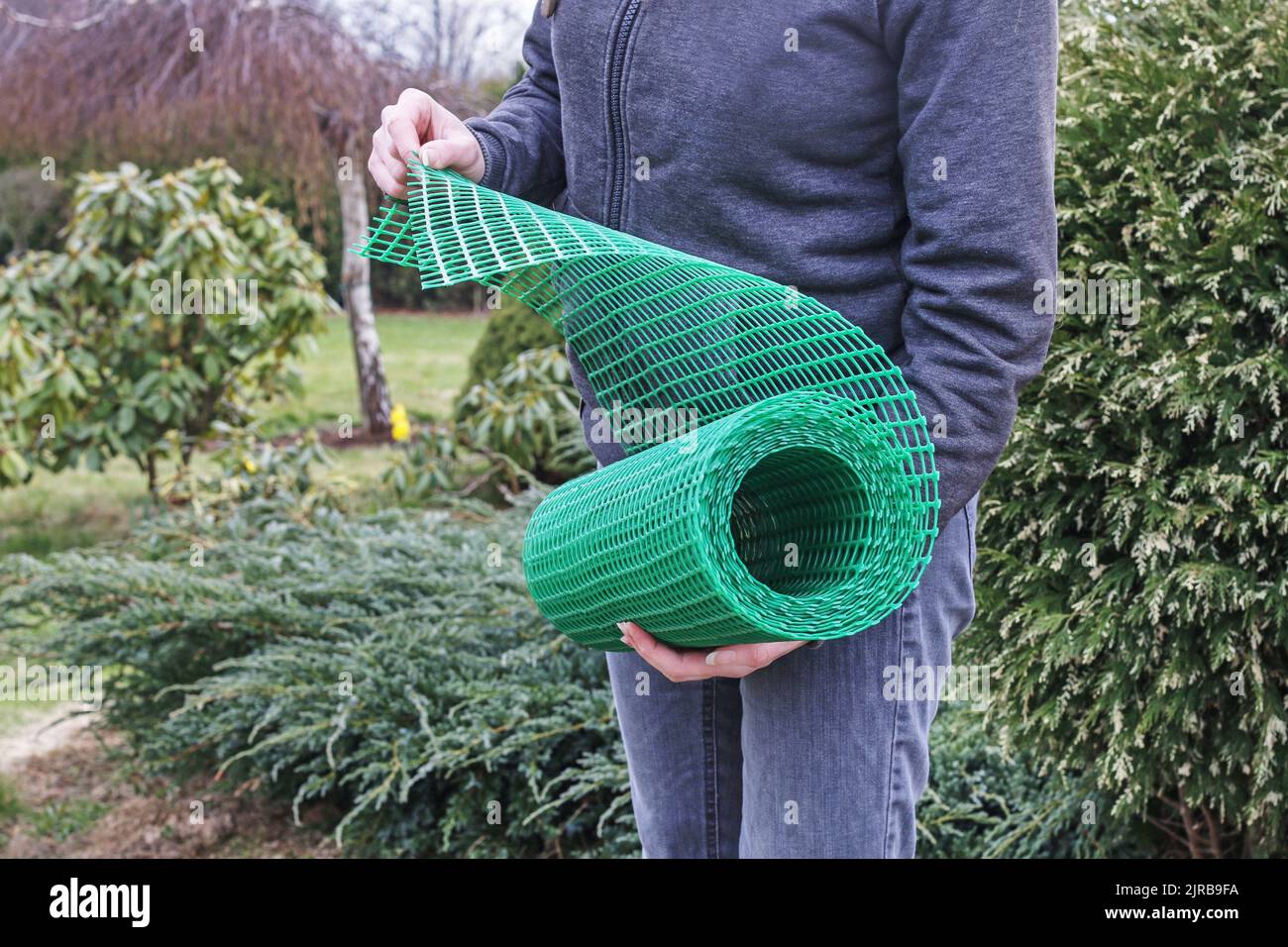 Une femme tient un filet en plastique qui est utile dans le jardinage.  Passe-temps dans le jardin Photo Stock - Alamy