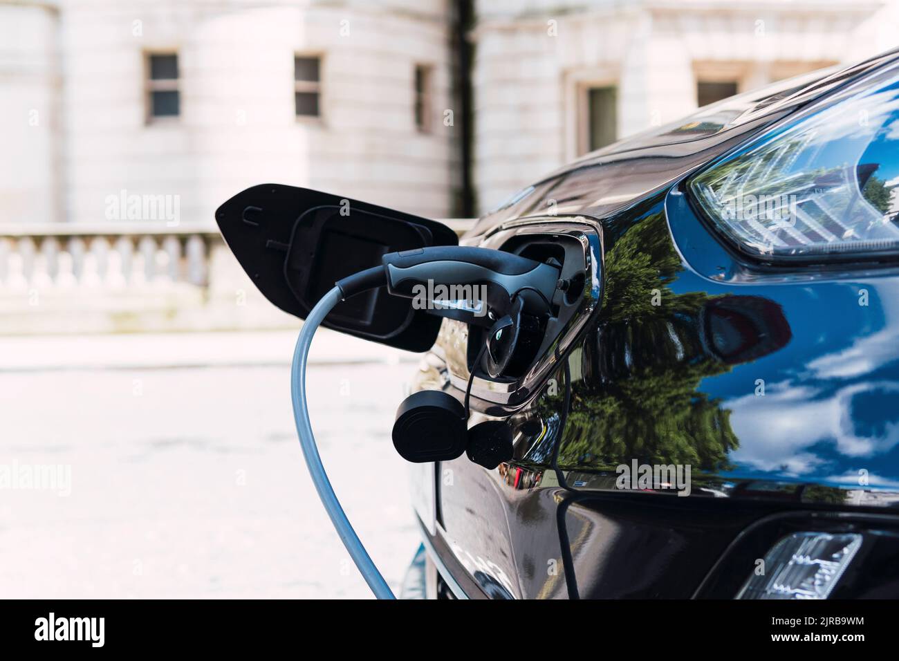 Câble de charge branché dans la voiture électrique au bord de la route Banque D'Images