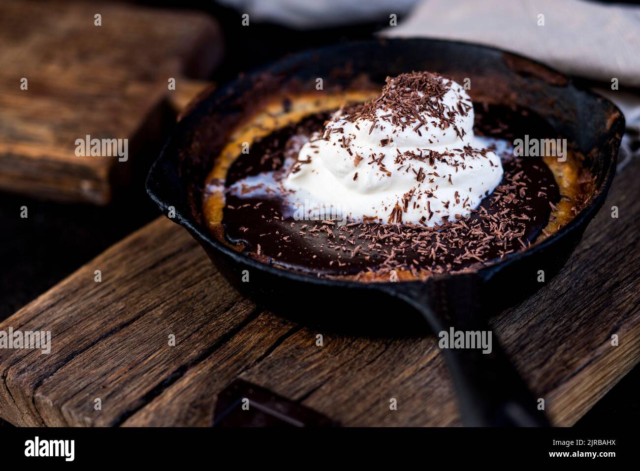 Poêle à frire avec biscuits aux pépites de chocolat recouverts de garniture de ganache et de crème fouettée Banque D'Images