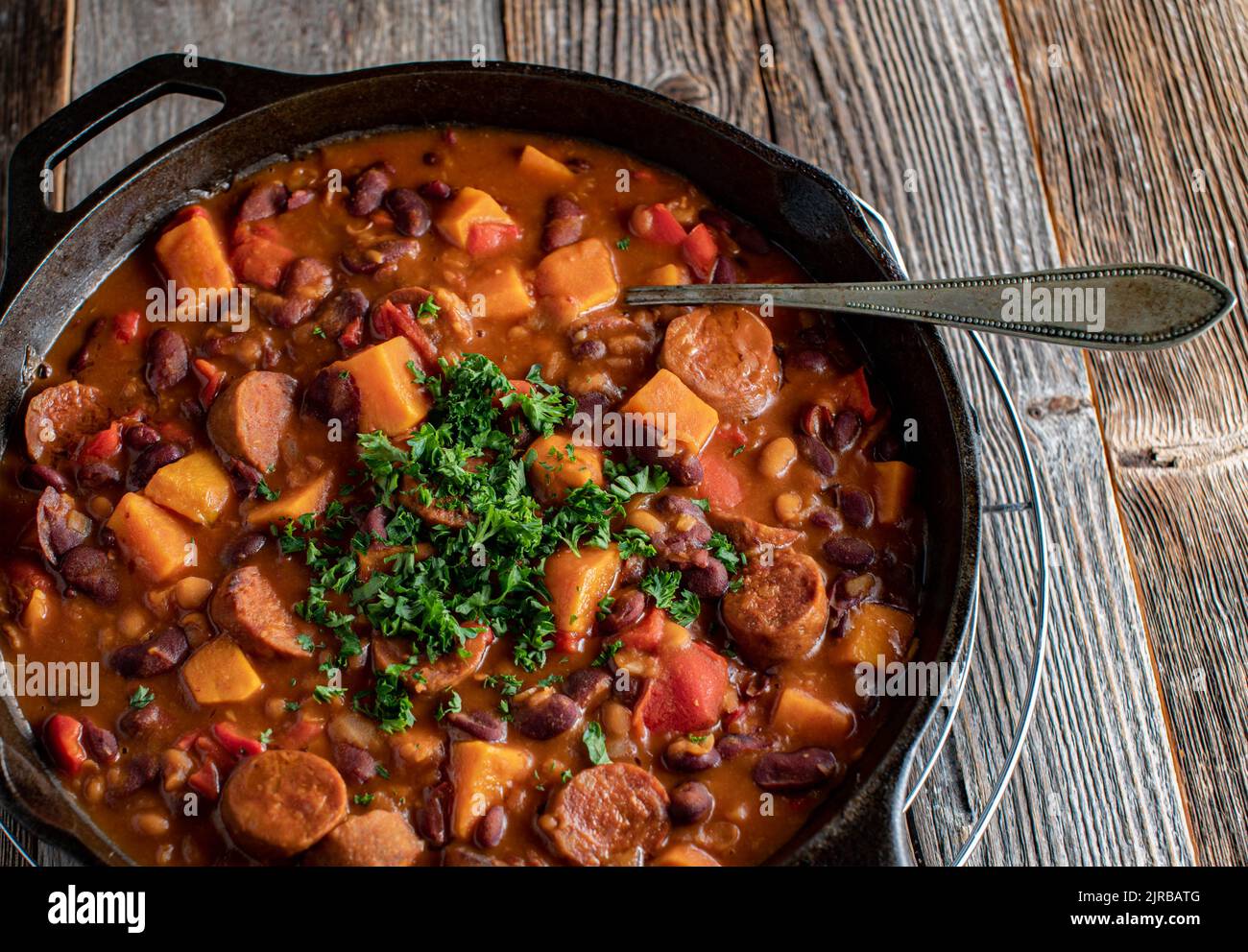Ragoût de saucisse de chorizo avec des patates douces, des haricots et des légumes dans une casserole en fonte Banque D'Images