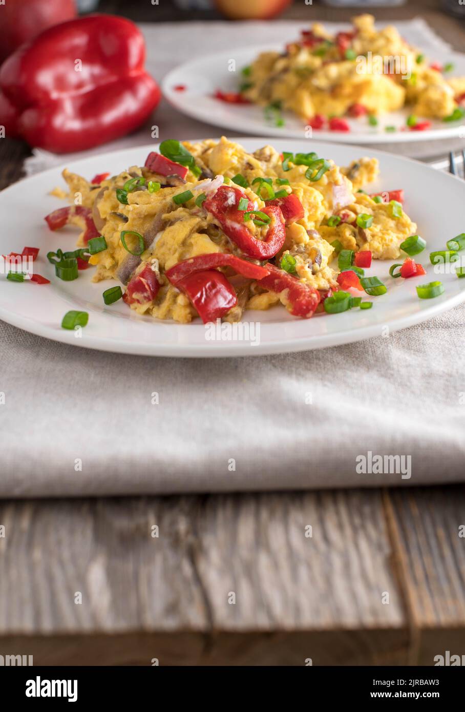 Petit déjeuner à base de glucides à la maison avec œufs brouillés et légumes. Deux plaques sur une table en bois avec espace de copie Banque D'Images