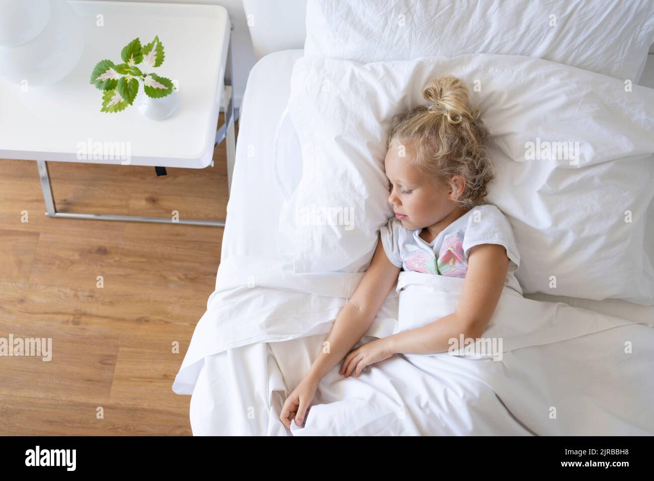 Blonde girl sleeping in bed Banque D'Images