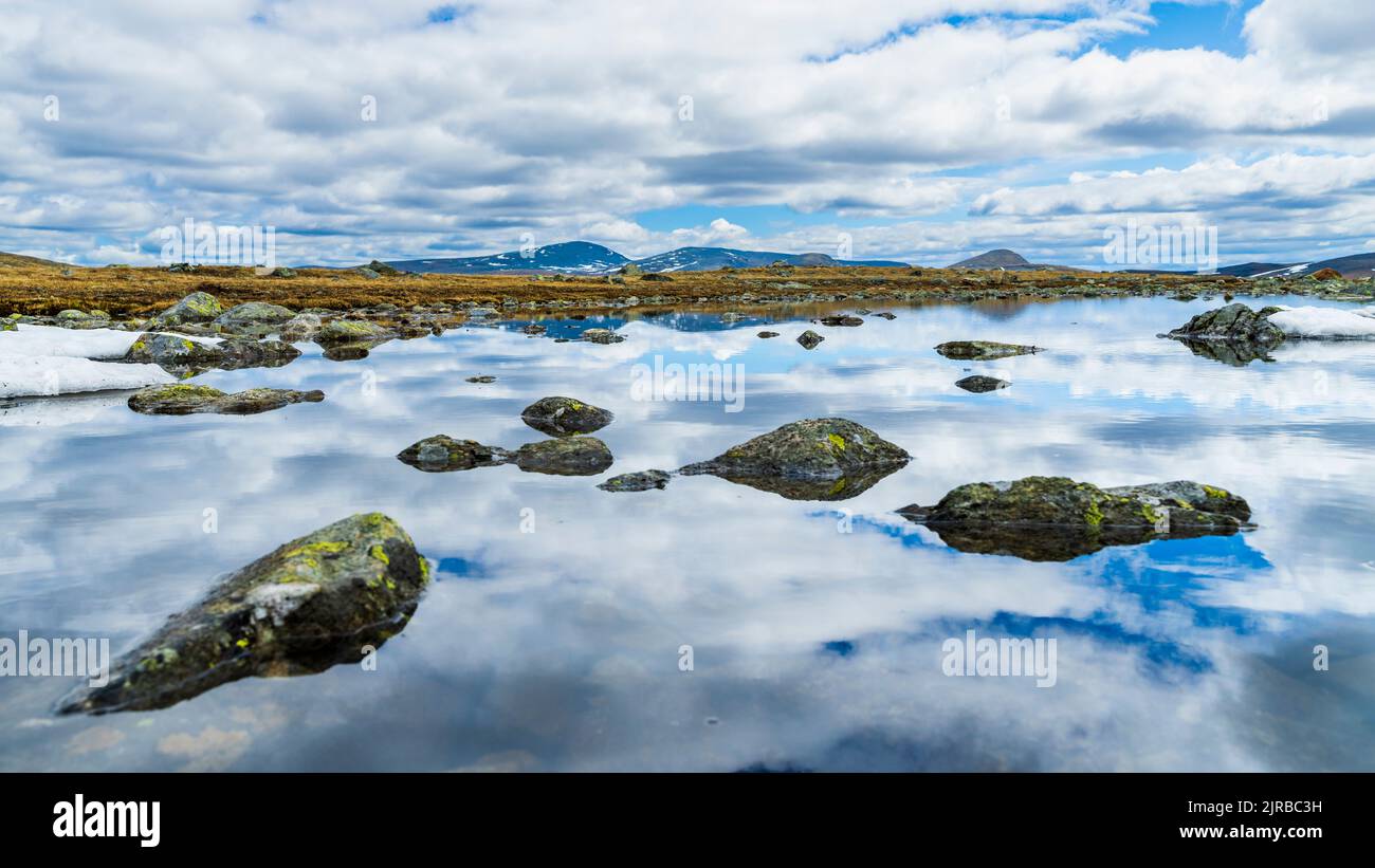 Norvège, Innlandet, nuages qui se réfléchit à la surface de la rivière qui coule dans le parc national de Jotunheimen Banque D'Images